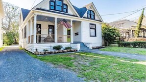 A two-story house with a porch, an American flag, and a well-maintained lawn. - Dauphin Darling 4 Units  (Mobile)