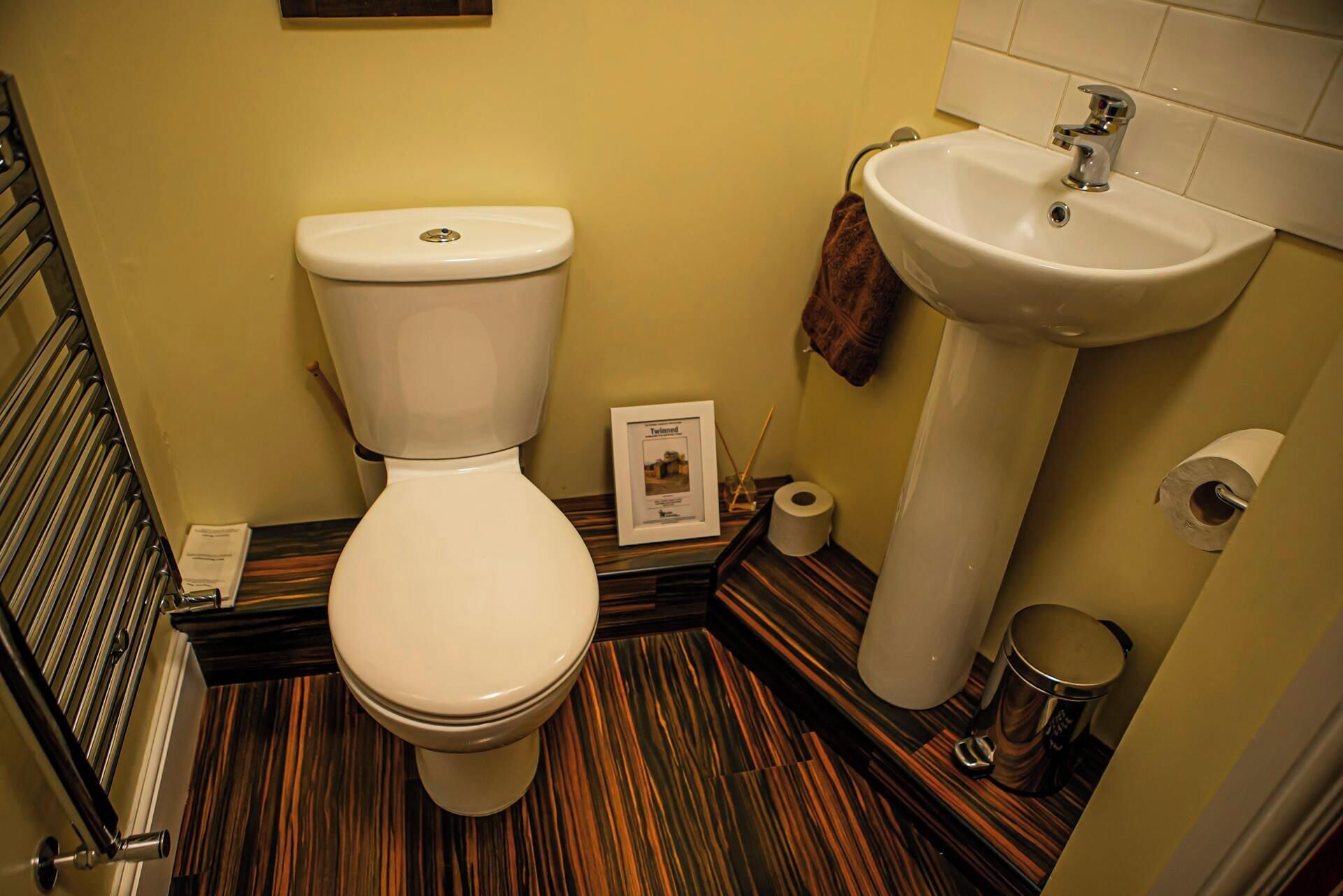 Un bagno con il water, lavandino e pavimento a righe.