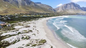 Un paisaje costero con playa, casas y montañas.