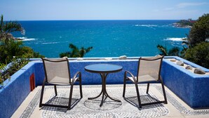 Una terraza con dos sillas y una mesa con vistas al océano.