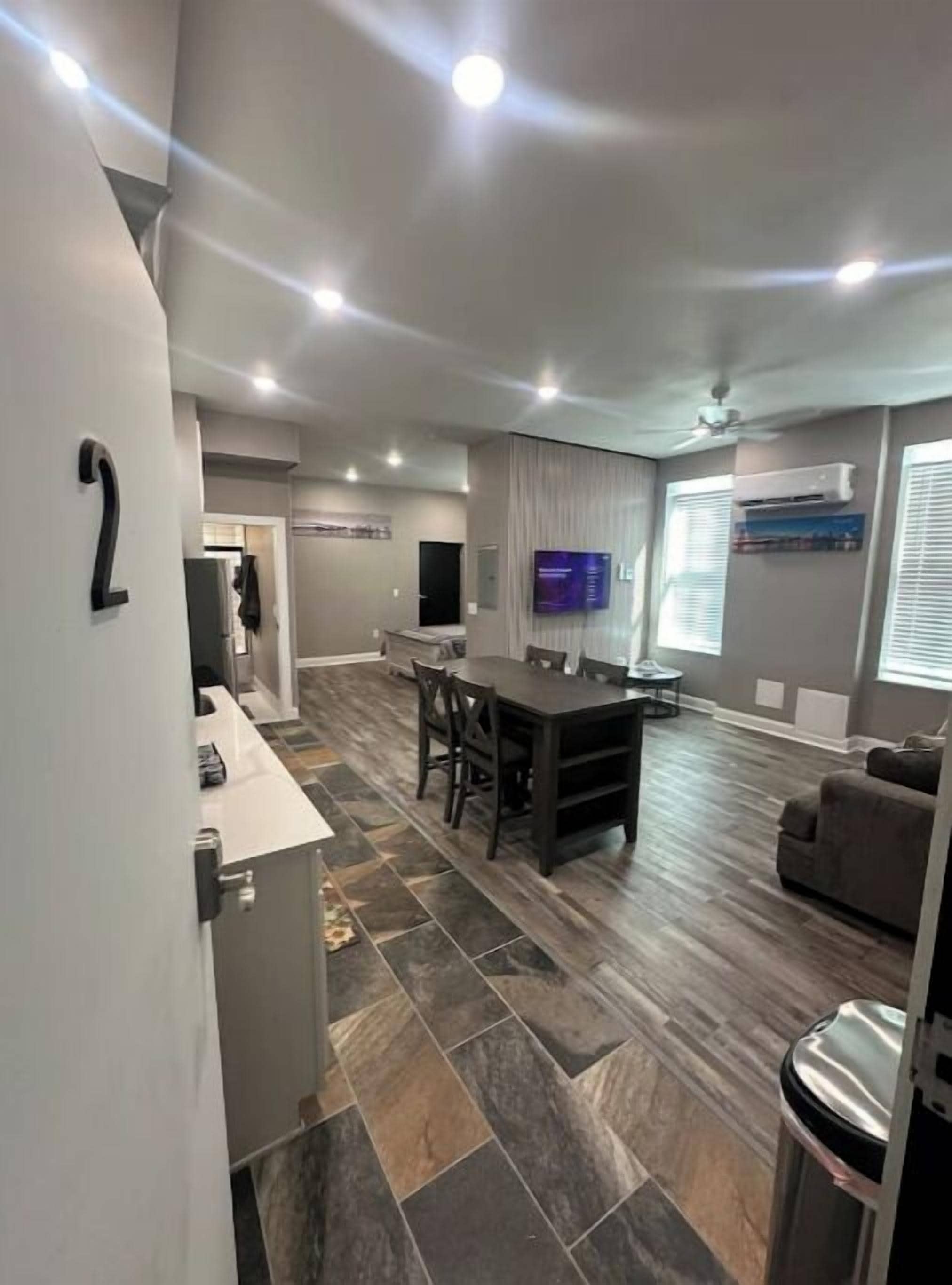 Una sala moderna con comedor, televisor y aire acondicionado.