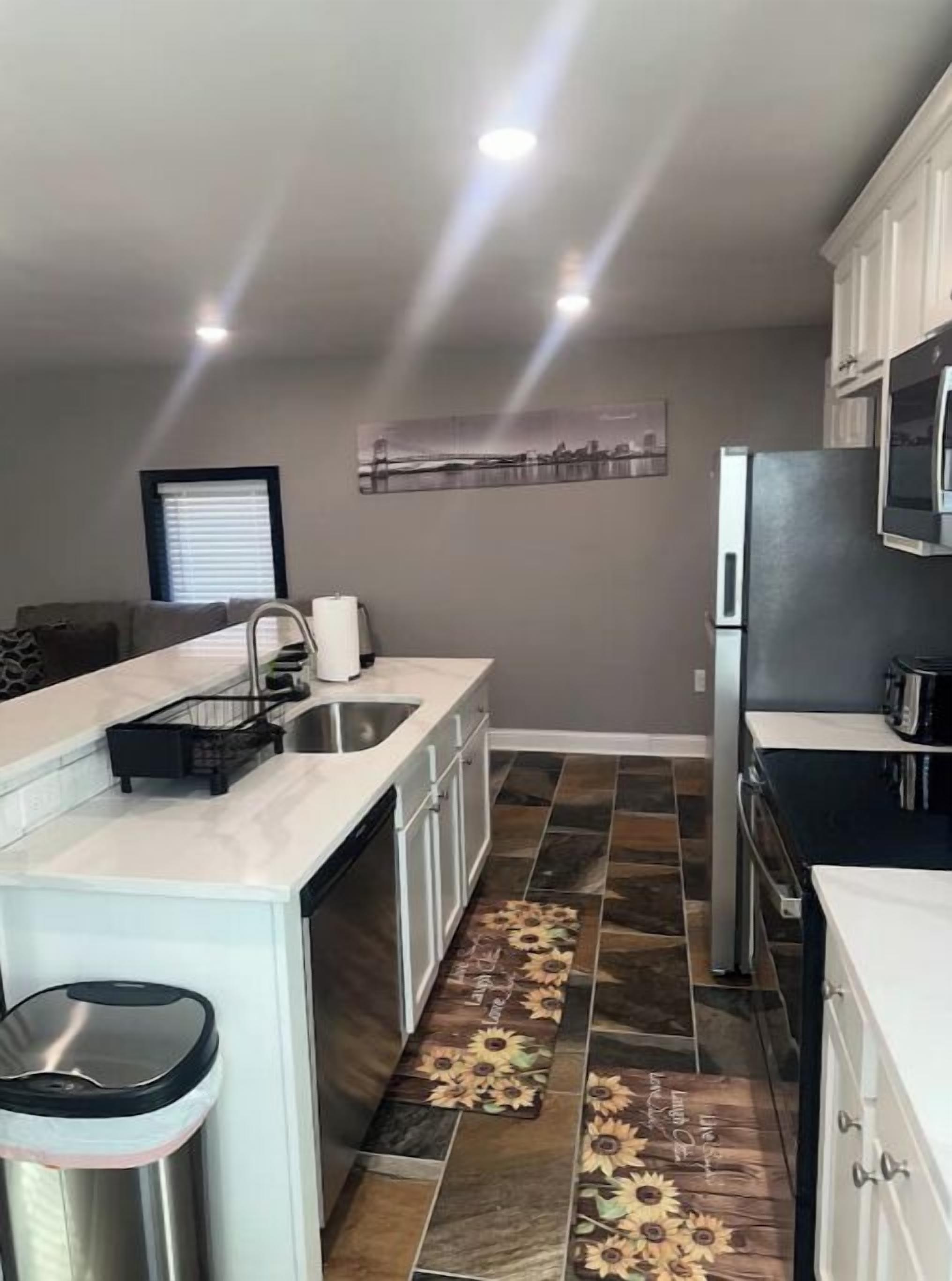 Een moderne keuken met een centraal eiland, roestvrijstalen apparatuur en een decoratieve spatwand.