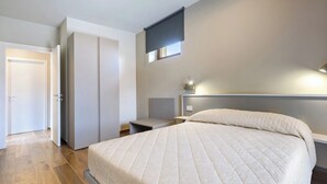 A bedroom with a bed, a wardrobe, a bedside table, and a nightstand. - Casa Matilla - Verde (La Morra)