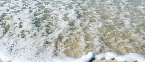 Ranta lähistöllä, aurinkotuoleja, rantapyyhkeitä