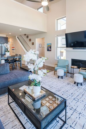 A spacious living room with a modern design, featuring a large sofa, a coffee table, and a fireplace. - Welcoming Modern Cabin: Free Resort Shuttle right outside! (Fraser)