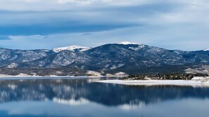 Ein ruhiger See mit schneebedeckten Bergen im Hintergrund.