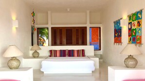 A bedroom with a white bed, two bedside tables with lamps, a colorful striped pillow, and a large window with wooden shutters. - Villa 4 Rec. con Vistas y Playa Privada (Santa María Huatulco)
