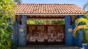 A building entrance with a tiled roof, a wooden gate, and a stone pathway. - Villa 4 Rec. con Vistas y Playa Privada (Santa María Huatulco)