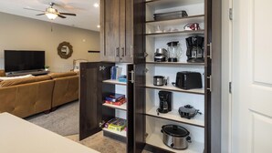 Una cocina compacta con electrodomésticos integrados, una zona de comedor con mesa y un salón con sofá y televisor.
