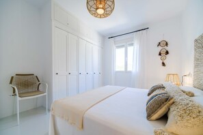 A bedroom with a large bed, a chair, and a wardrobe. - Villa Casablanca Pinosol Javea, Designer Villa with Private Pool (Javea / Xàbia)