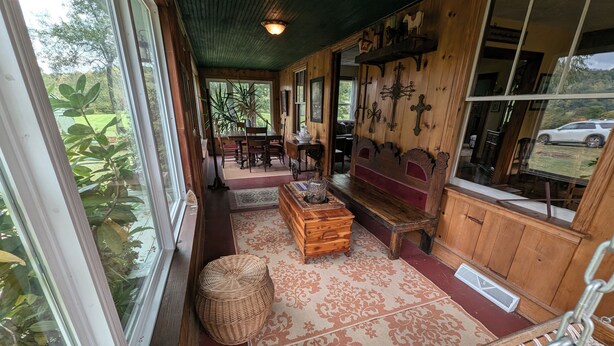 Una habitación acogedora con un banco de madera, una cesta de mimbre y una alfombra estampada.