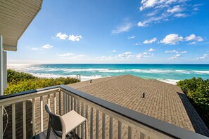 A balcony with a view of the ocean, a chair, and a railing. - Melbourne Beach Oceanfront Apartment Unit #2 - Ocean Views (Melbourne Beach)
