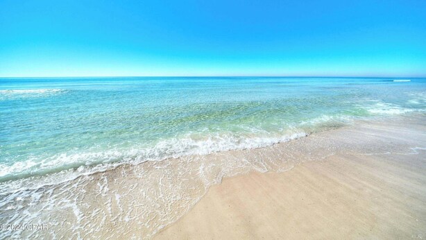 Una spiaggia con acque cristalline e una costa sabbiosa.