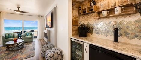 A modern kitchen with a dishwasher, a coffee machine, and a wine rack.