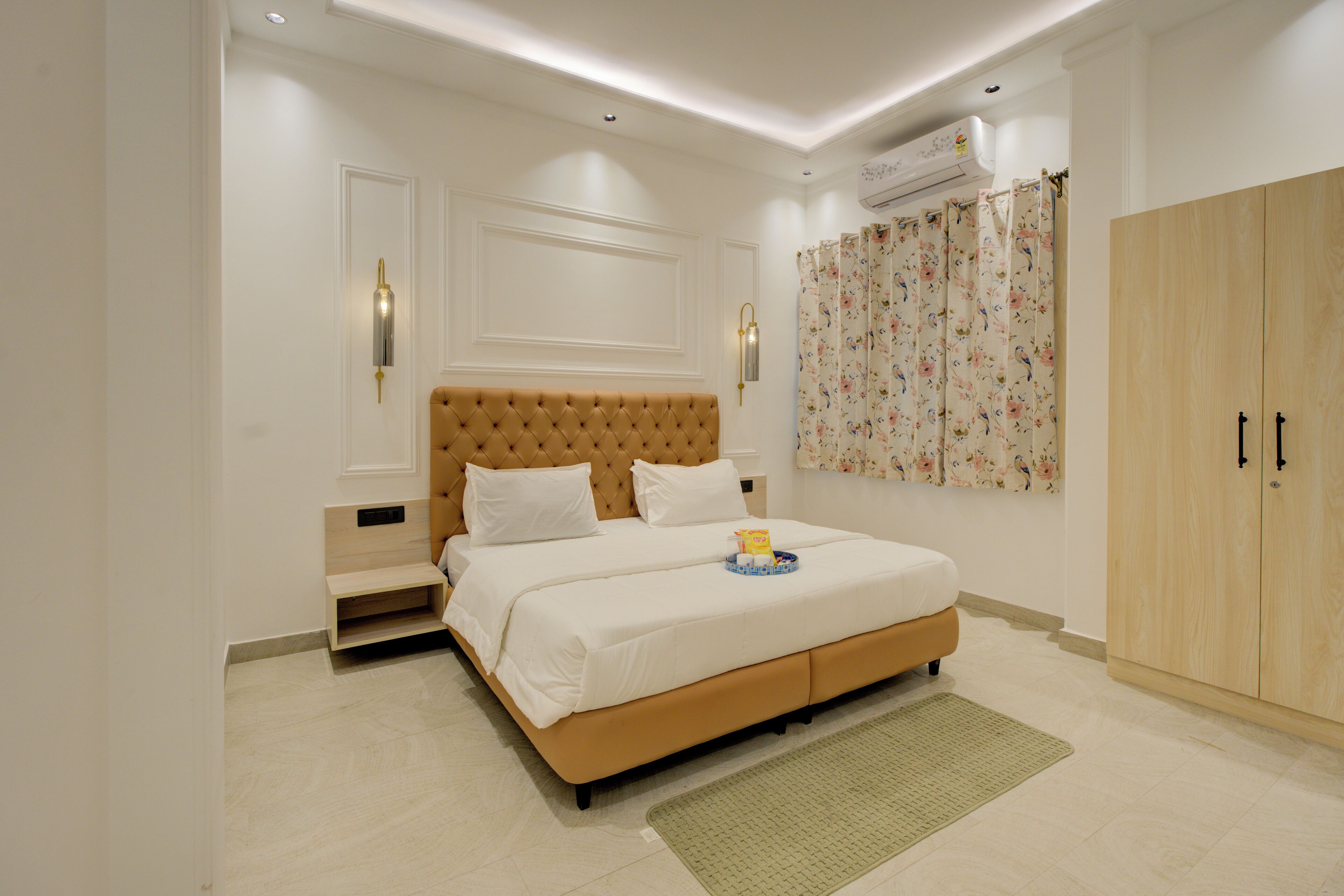 Un dormitorio con una cama grande, un armario, una mesita de noche y un aire acondicionado instalado en la pared.