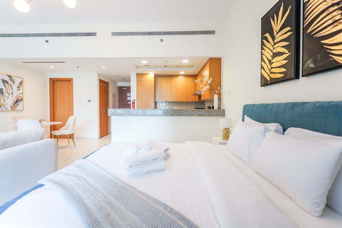 Een hotelkamer met een bed, een zithoek en een kitchenette.