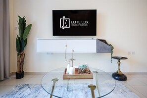 A modern living room with a mounted television, a glass coffee table, and a minimalist decor. - Modern Comfort Studio Near Downtown Dubai (Dubai)