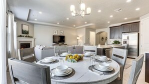 A modern kitchen with a central island, built-in appliances, and a dining area set for six. - 28 Mi to Zion Nat’l Park: Modern Washington Home (Washington)