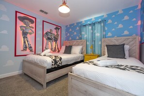Ein Schlafzimmer mit zwei Betten, einem Holz-Kopfteil, einem Nachttisch und einer Deckenleuchte.