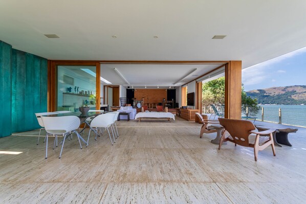 A spacious living area with a large bed, seating area, and a view of the water.