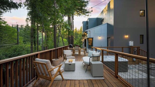 A deck with outdoor furniture, a grill, and a view of a forested area. - Mill Creek by Avantstay Modern Design, Patio, Hot Tub (Healdsburg)