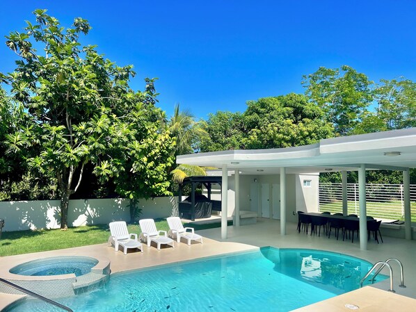 A swimming pool with lounge chairs, a covered patio, and a view of trees. - Unique Top Caribbean Private Retreat (LUQUILLO)