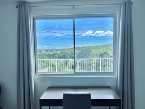 Enjoy a serene view of the lush landscape from the balcony through the large window.
