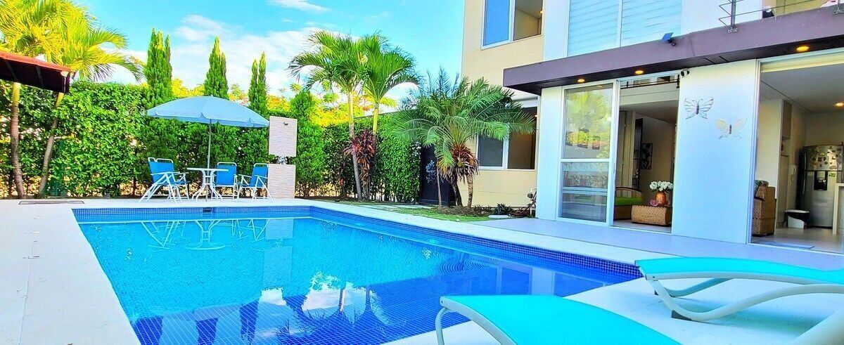 A modern house with a swimming pool, outdoor furniture, and a well-maintained garden.