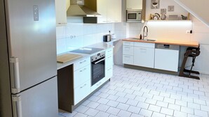 Eine moderne Küche mit weißen Schränken, einem Backofen, einer Mikrowelle und einem Spülbecken.