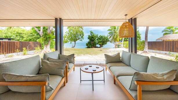 Ein Sitzbereich im Freien mit Blick auf Strand und Meer.