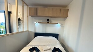 Une chambre à coucher avec un lit, un miroir et des armoires en bois encastrées au-dessus du lit.