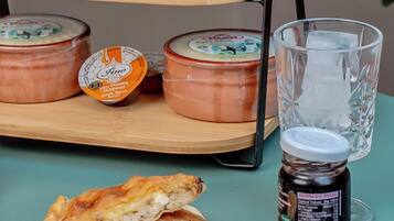 Une table avec des pâtisseries, du fromage et un pot de confiture.