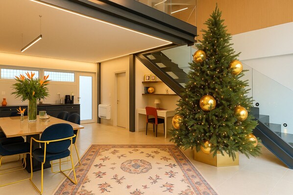 A modern interior with a staircase, a dining area, and a Christmas tree. - Apeiron Athena Residences (Athens)