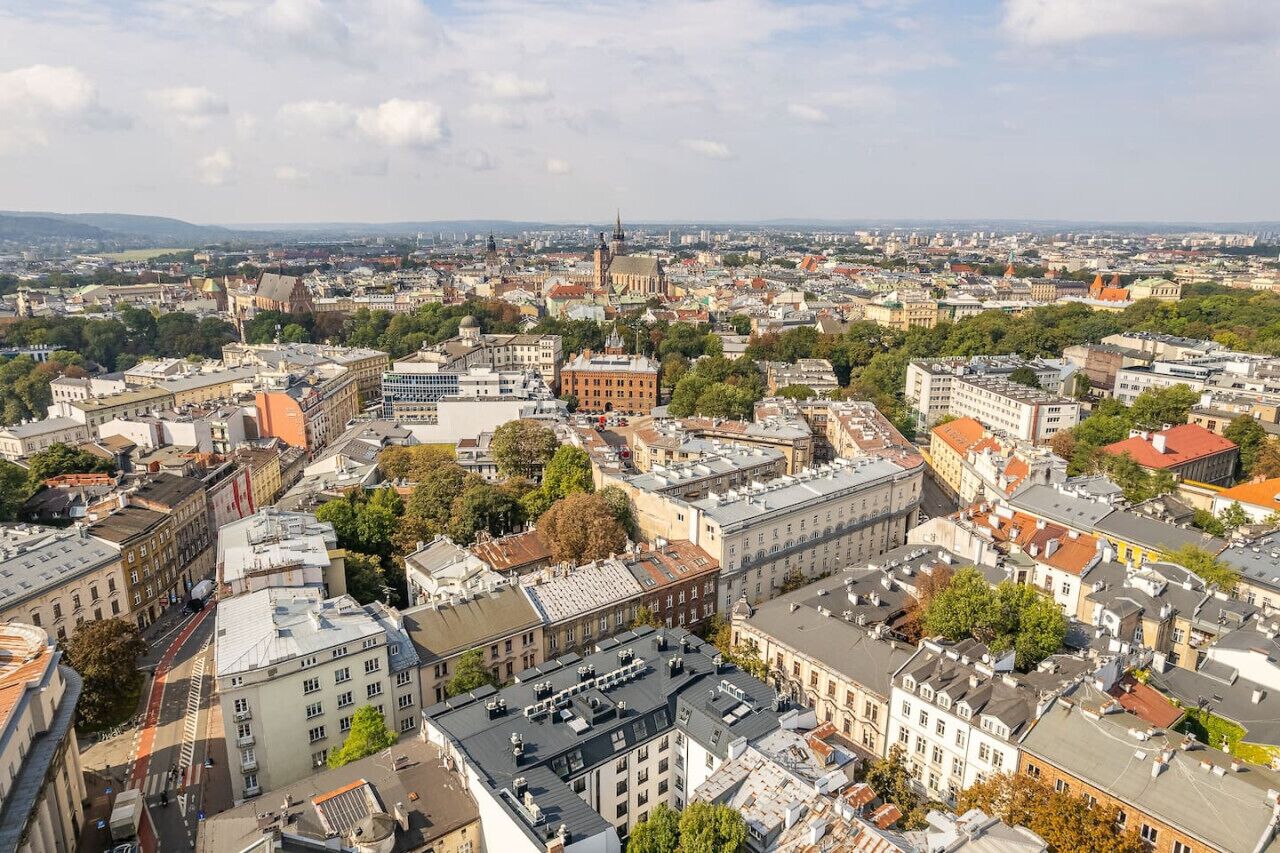 A cityscape with a mix of historical and modern buildings, including a prominent church spire.