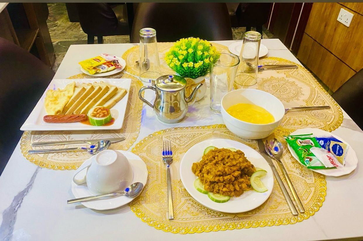 A dining table set with various dishes, a pitcher, and a vase of flowers.