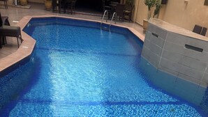 A swimming pool with a tiled floor and a built-in seating area. - PRESKEN HOTELS FAJODD4 (Lagos)