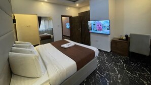 A modern hotel room with a large bed, a TV mounted on the wall, and a mirror. - PRESKEN HOTELS FAJODD4 (Lagos)