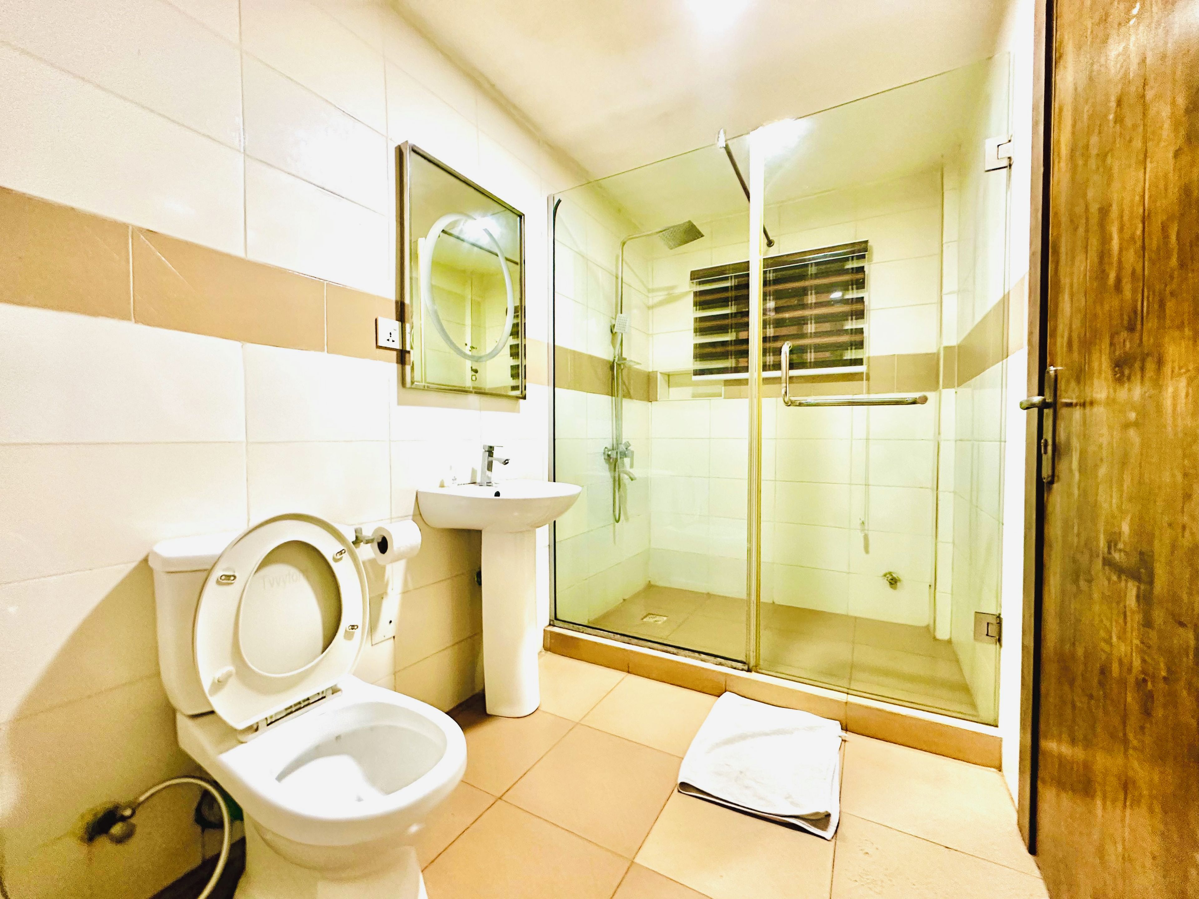 A bathroom with a toilet, sink, and glass-enclosed shower area.