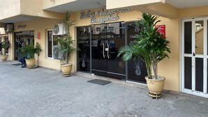 A hotel reception with a balcony, large potted plants, and a sign indicating a lounge area. - PRESKEN HOTELS FAJODD4 (Lagos)