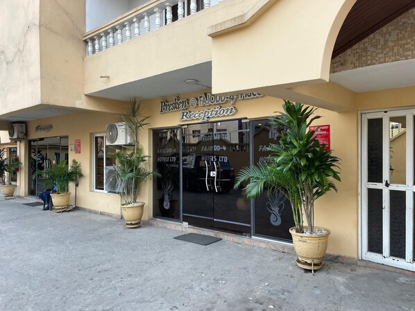 A hotel reception with a balcony, large potted plants, and a sign indicating a lounge area. - PRESKEN HOTELS FAJODD4 (Lagos)