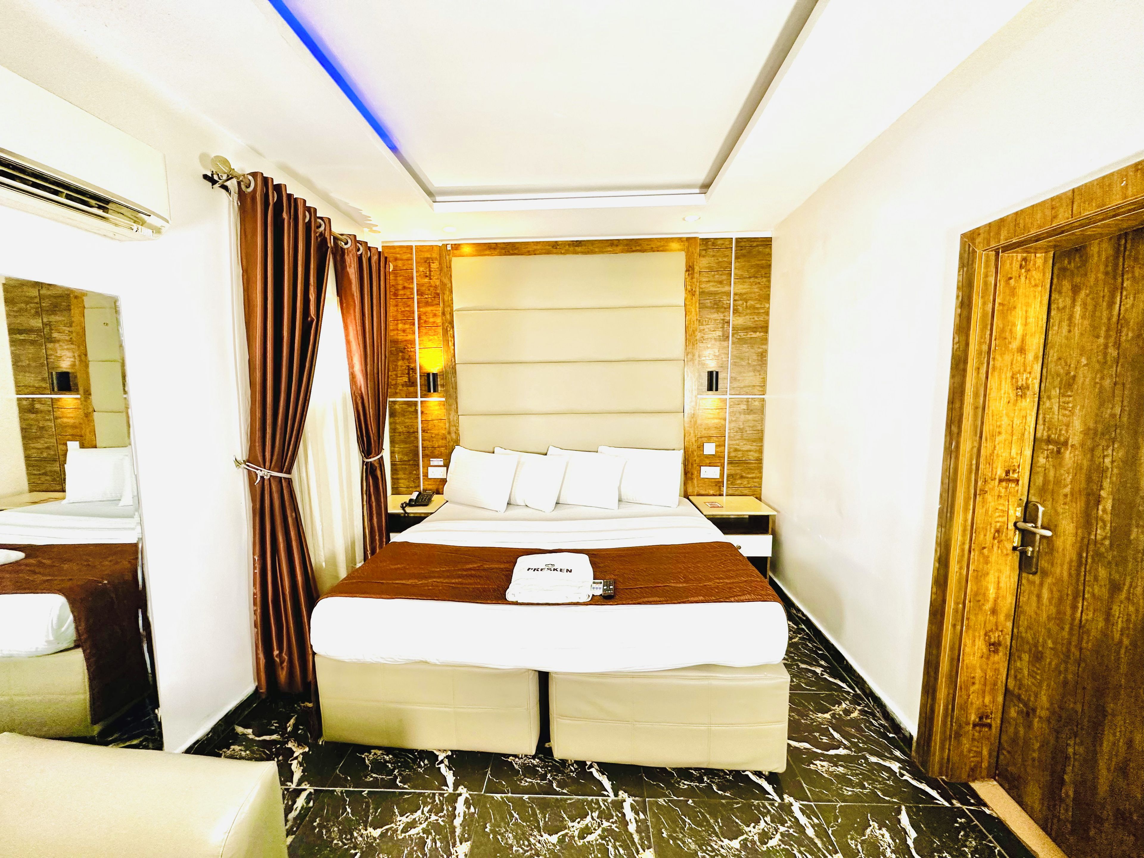 Una habitación de hotel con una cama grande, una mesita de noche y un espejo.