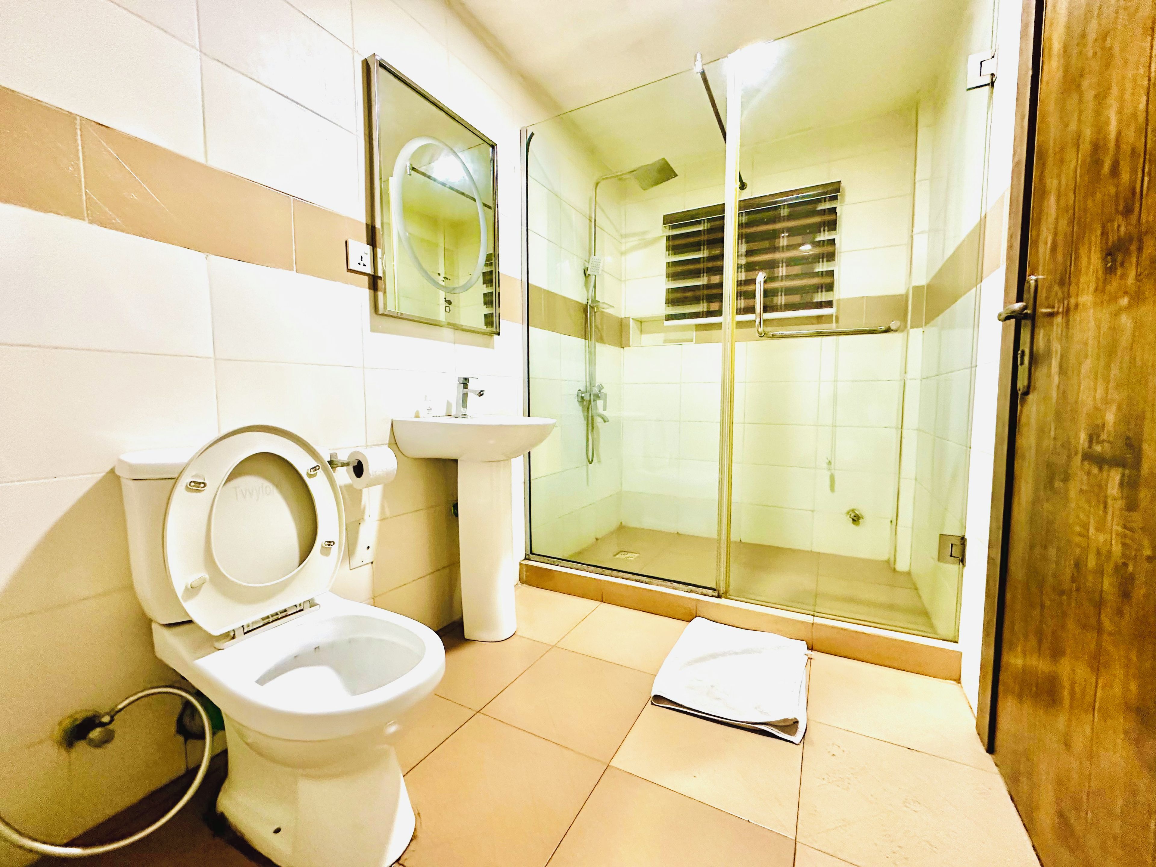 Un bagno con WC, lavandino e box doccia in vetro.