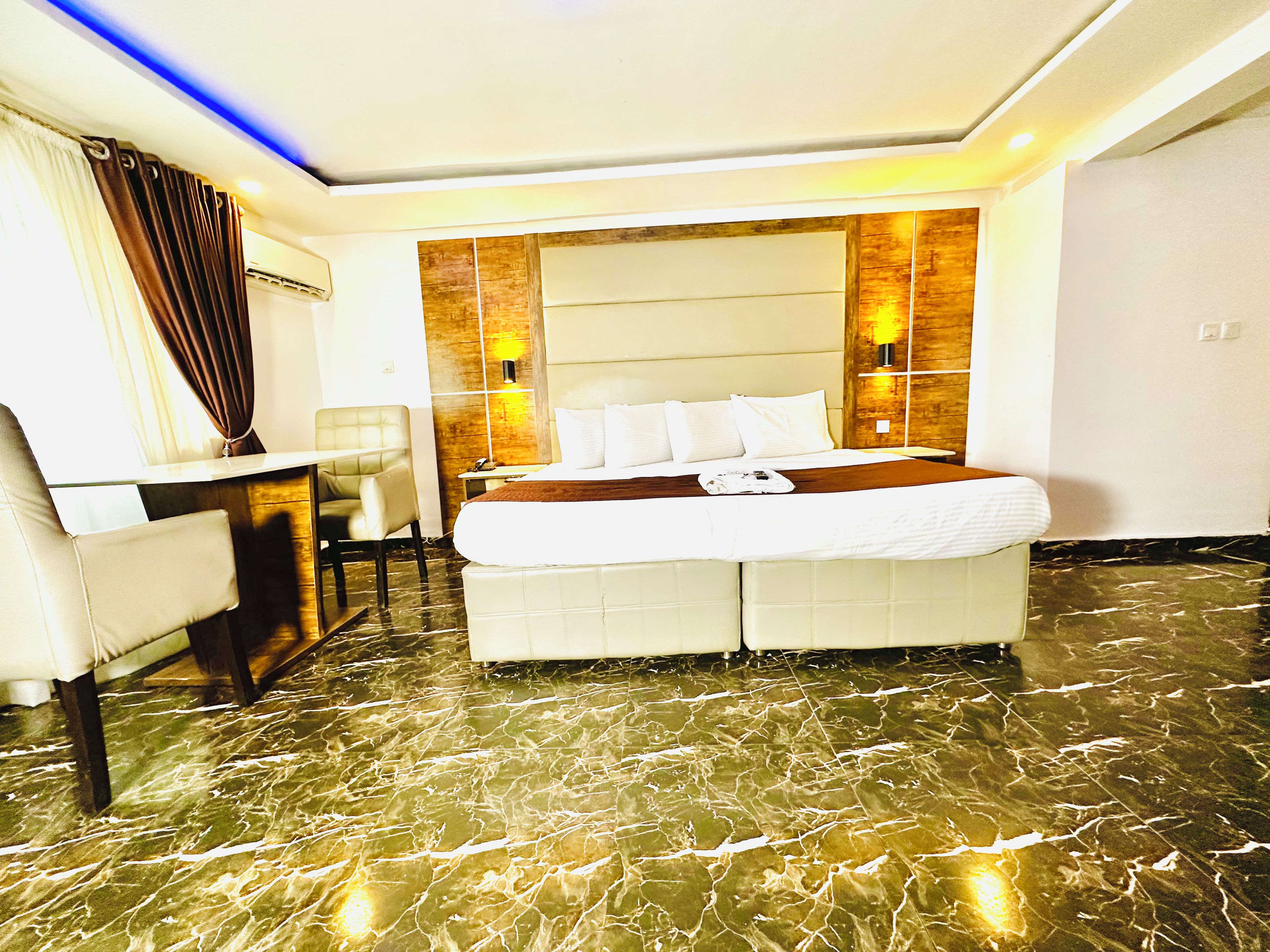 A hotel room with a bed, a desk, and a chair.