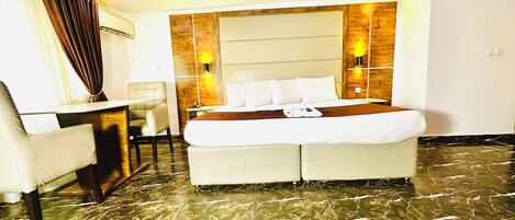 A hotel room with a bed, a desk, and a chair.