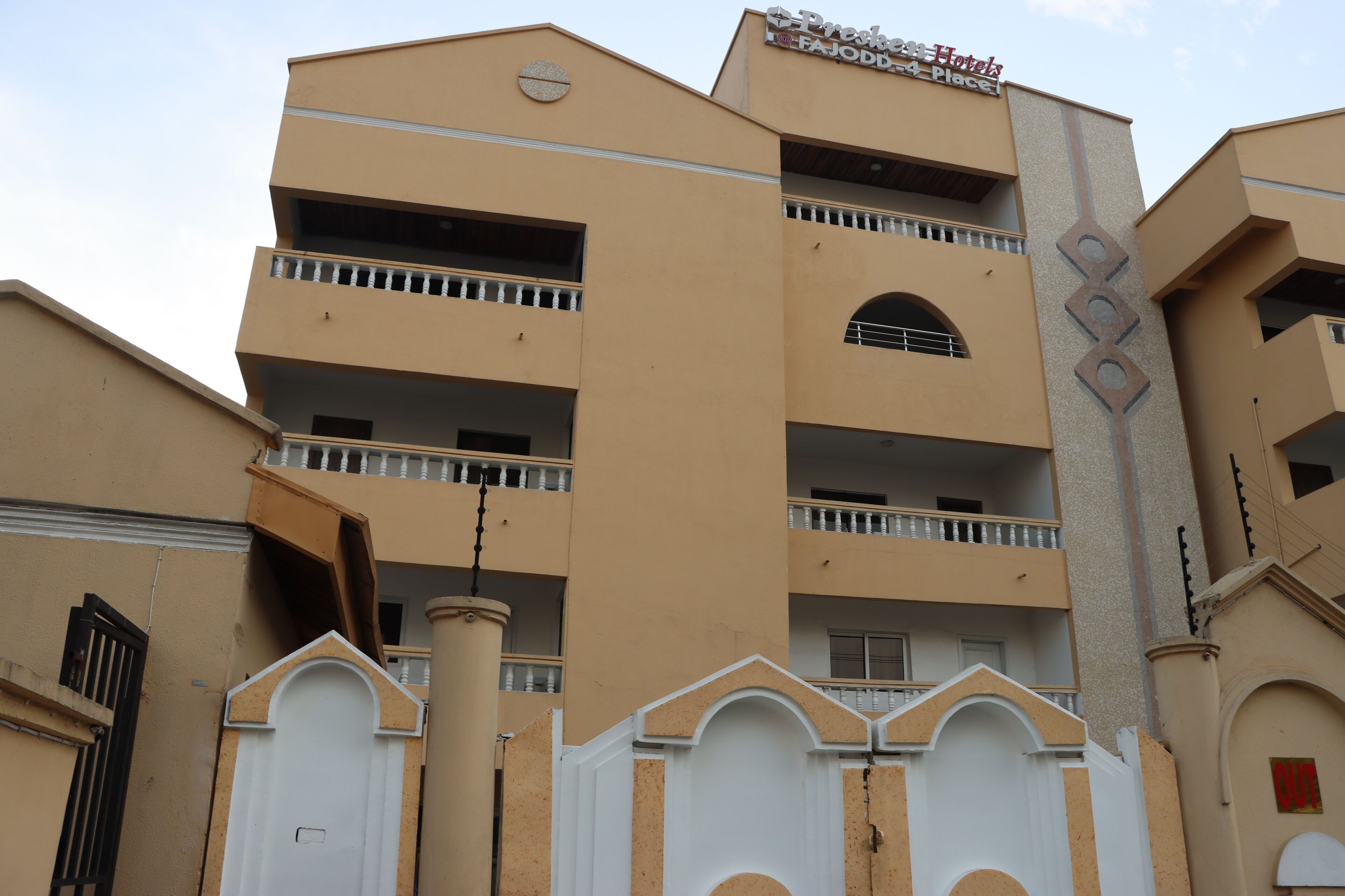 A multi-story hotel with balconies, a prominent entrance gate, and a sign indicating it is a 4-star establishment.
