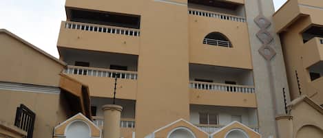 A multi-story hotel with balconies, a prominent entrance gate, and a sign indicating it is a 4-star establishment.