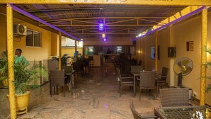 A hotel lobby with a central bar area, wicker furniture, and potted plants. - PRESKEN HOTELS FAJODD4 (Lagos)