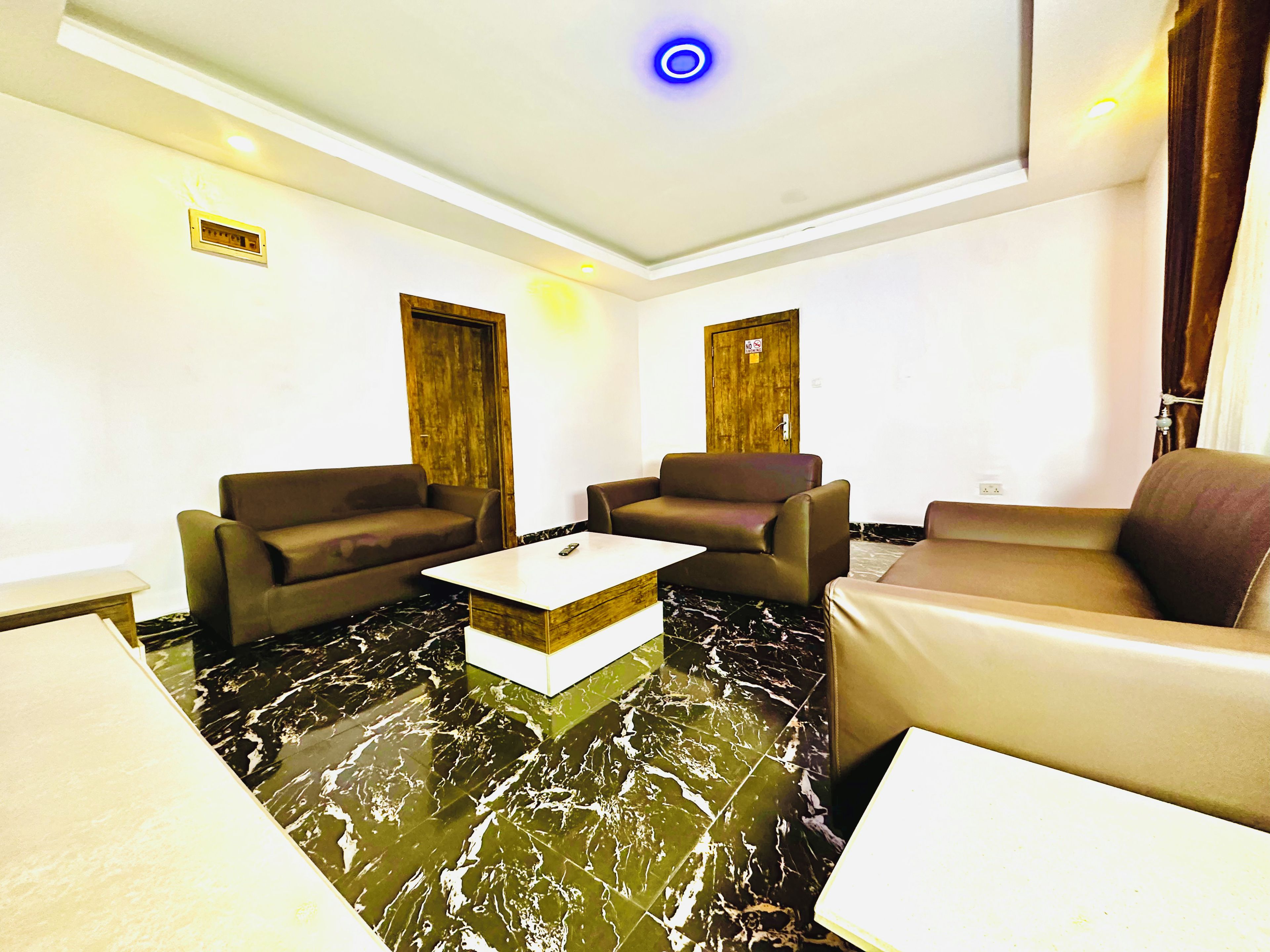 Una sala de estar moderna con dos sofás, una mesa de centro y una puerta de madera.