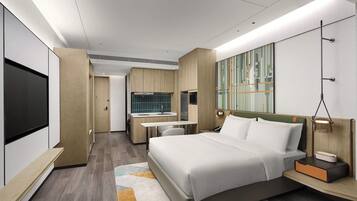 A modern hotel room with a large bed, a desk, a mirror, and a TV.