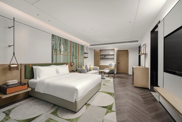 A modern hotel room with a large bed, a desk, a chair, and a TV. - Holiday Inn Chongqing Science Hall by IHG (Chongqing)